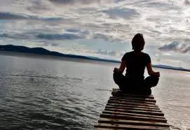 Calming photo of a person sitting on a dock