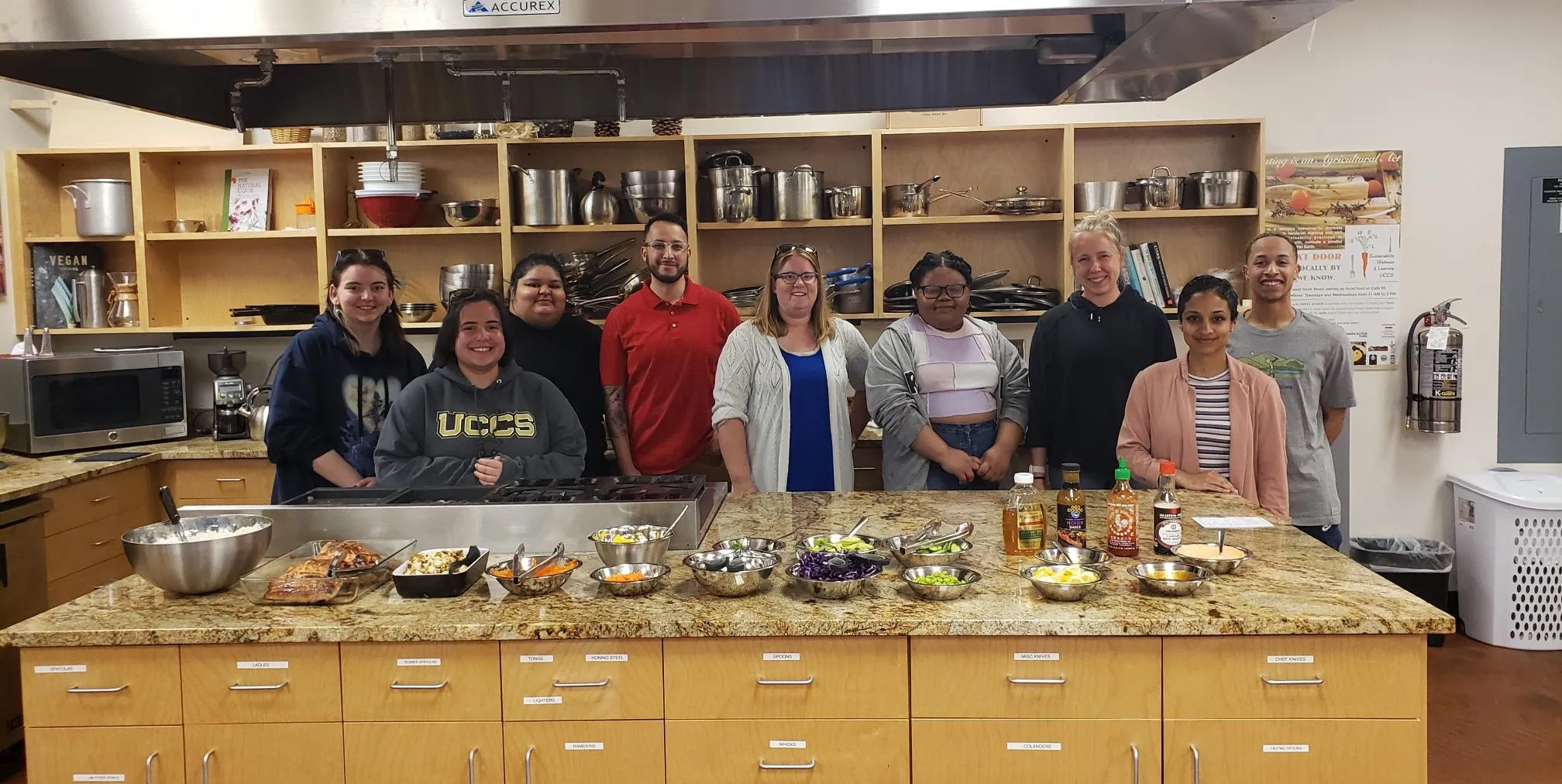 Group of 9 people who attended the cooking class with their finished cooking dishes